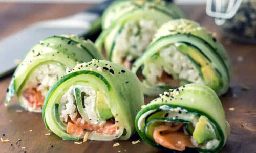 An elegant arrangement of Cucumber Sushi rolls on a clean bamboo board.